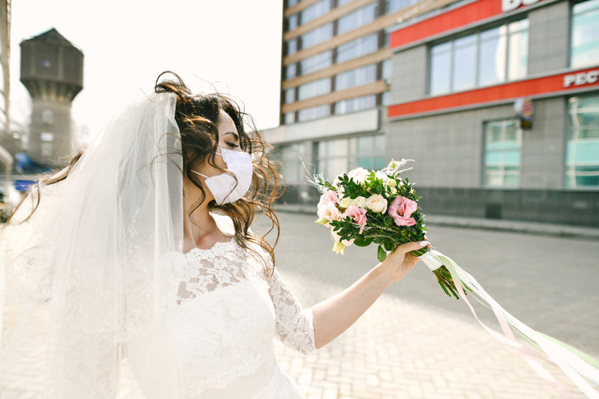 a-bride-wears-dress-and-face-mask